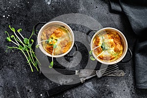 Cheese omelette , omelet with microgreens in a pan. Black background. Top view