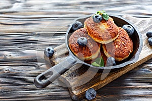 Cheese pancakes and blueberries in cast iron pan.