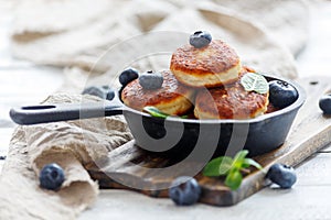 Cheese pancakes and blueberries in cast iron pan.