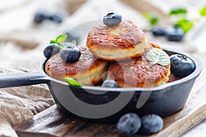 Cheese pancakes and blueberries in cast iron pan