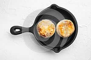 Cheese pancakes  on cast iron frying pan skillet on cast iron frying pan skillet, top view flat lay, on white stone table