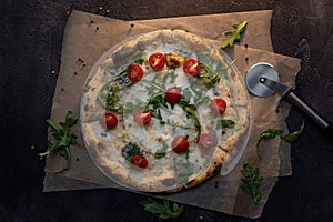 Cheese pizza with paper and knife on dark concrete background top view