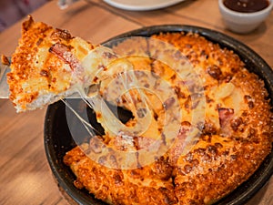 Cheese pizza on wooden board. slid pieace growing cheddar cheese, restaurant table. fastfood concept