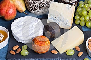 Cheese plate. 5 species of cheese, fruit, nuts, wine jug.