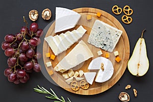 Cheese plate. Assorted cheeses with fruits, walnuts and pretzels. Food for wine.