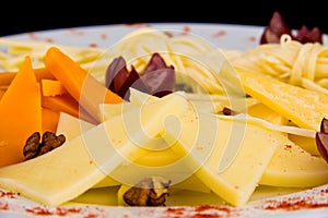 Cheese plate - Charcuterie Board with various types of hard cheese and String cheese., decorated with grapes close up