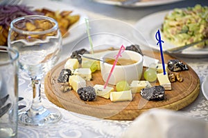 Cheese plate with cheeses Parmesan, Brie, Camembert and Roquefort in serving on the table from an old tree close-up