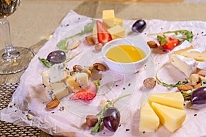 Cheese plate with cheeses Dorblu, Parmesan, Brie, Camembert and Roquefort in serving on the table from an old tree close