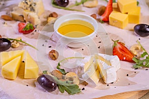 Cheese plate with cheeses Dorblu, Parmesan, Brie, Camembert and Roquefort in serving on the table from an old tree close