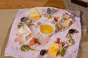 Cheese plate with cheeses Dorblu, Parmesan, Brie, Camembert and Roquefort in serving on the table from an old tree close