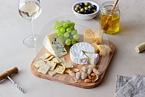 Cheese plate with cracker, almonds and grapes. Wine appetizer. Wine snack