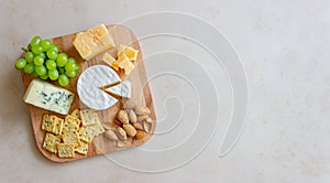 Cheese plate with cracker, almonds and grapes. Wine appetizer. Wine snack