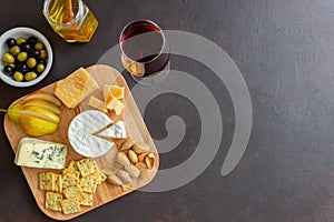 Cheese plate with cracker, almonds and grapes. Wine appetizer. Wine snack