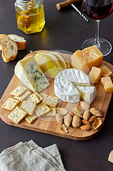 Cheese plate with cracker, almonds and grapes. Wine appetizer. Wine snack