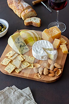 Cheese plate with cracker, almonds and grapes. Wine appetizer. Wine snack