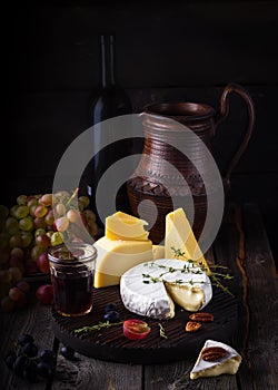 Cheese plate,grape and wine. Still life in rustic style.