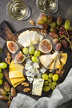 Cheese plate with grapes, figs and nuts.