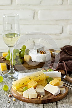 Cheese plate with grapes,  wine glass and nuts. Copy space