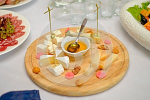 Cheese plate served with white wine, crackers and nuts, Top view. Assorted cheeses Camembert, Brie, Parmesan blue cheese