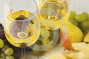 Cheese plate served with wine, fresh grapes and pears