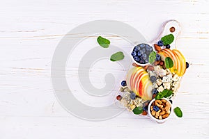 Cheese platter with assorted cheeses, blueberry, apples, nuts on white table