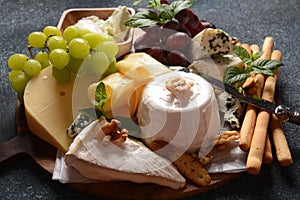 Cheese platter with assorted cheeses, grapes, nuts and snacks