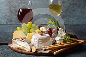 Cheese platter with assorted cheeses, grapes, nuts and snacks .