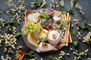 Cheese platter with assorted cheeses, grapes, nuts and snacks