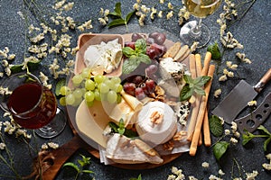 Cheese platter with assorted cheeses, grapes, nuts and snacks