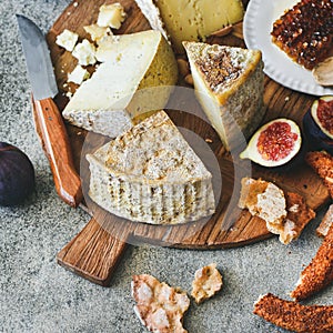 Cheese assortment, figs, honey, fresh bread and nuts, square crop