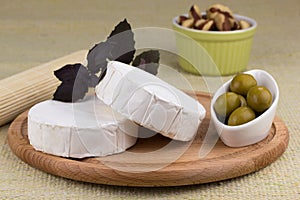 Cheese platter with nuts and grapes and olives