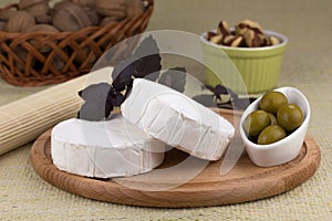 Cheese platter with nuts and grapes and olives