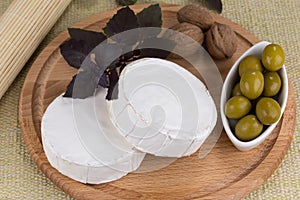 Cheese platter with nuts and grapes and olives