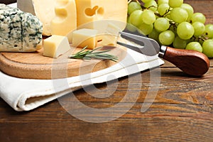 Cheese platter with rosemary, grapes and fork