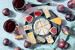 Cheese platter, shot from the top with wine and fresh fruit, a flat lay