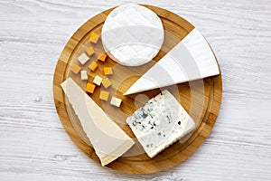 Cheese platter on a white wooden background. Food for wine, top view.