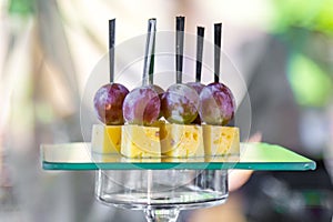 Cheese and plum on a glass stand of the corporate table