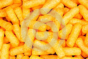 Cheese puff texture pattern background. Cheese puff snack snacks as background.