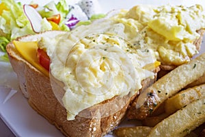 Cheese scram bled egg, white bread loaf, mixed greens and french fries