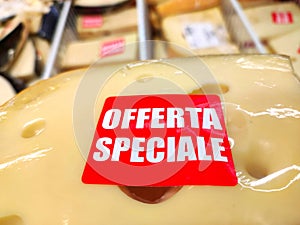 A piece of cheese with holes, being sold at a discount, with the words Special Offer in Italian photo