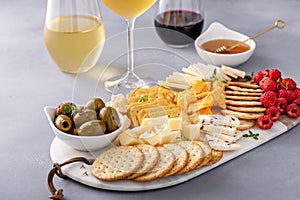 Cheese and snacks board with olives and crackers