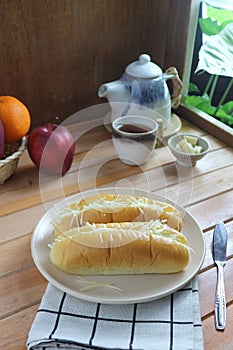 cheese-stuffed bread served on a white plate with apples and a teapot in the background