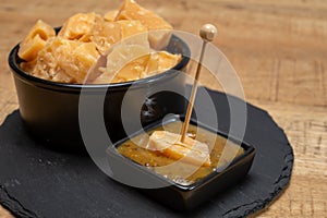 Cheese tasting, small pieces of old Dutch hard cheese and bowl with homemade dill-mustard sauce