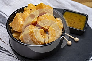 Cheese tasting, small pieces of old Dutch hard cheese and bowl with homemade dill-mustard sauce