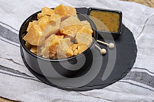 Cheese tasting, small pieces of old Dutch hard cheese and bowl with homemade dill-mustard sauce