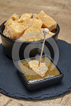 Cheese tasting, small pieces of old Dutch hard cheese and bowl with homemade dill-mustard sauce