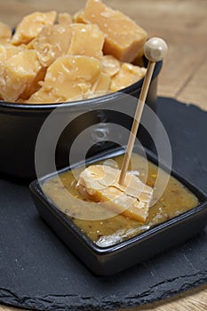 Cheese tasting, small pieces of old Dutch hard cheese and bowl with homemade dill-mustard sauce