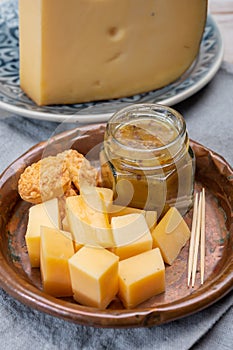 Cheese tasting, small pieces of old Dutch hard cheese and bowl with homemade dill-mustard sauce