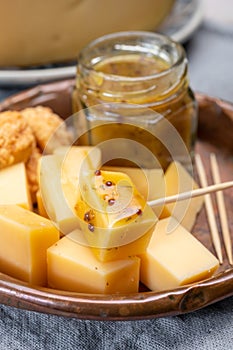 Cheese tasting, small pieces of old Dutch hard cheese and bowl with homemade dill-mustard sauce