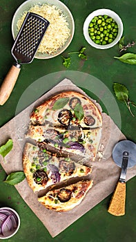 Cheese vegetable tortillas with eggplant, peas, red onion and mozzarella on a green background